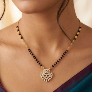 Gold plated mangalsutra necklace with CZ crystal heart pendant and black beads flat lay