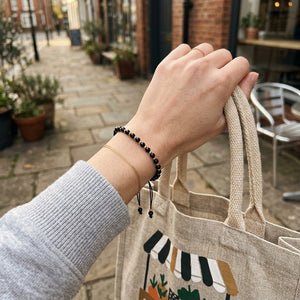 Adjustable Gold Black Beads Bracelet For Newborns and Adults (Worn on Wrist with Tote Bag) | The Colourful Aura
