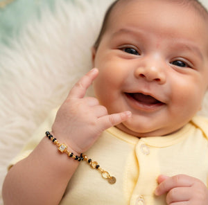 Close-up detail of baby Nazaria bracelet black beads gold balls crystal square charm gold plated brass