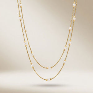 Full length view of an 18ct gold plated double strand imitation pearl and gold bead necklace on a neutral background