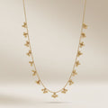 Full length view of an 18ct gold plated brass necklace with dangling ball cluster charms on a neutral background