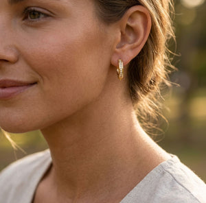 Woman wearing gold crystal huggie hoop earrings lifestyle shot boho jewellery UK The Colourful Aura
