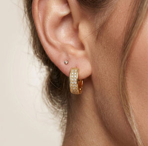 Woman wearing gold double row pavé crystal huggie hoop earrings lifestyle shot gold jewellery UK The Colourful Aura