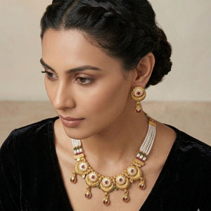 Gold granulation disc choker necklace with white floral enamel and ruby accents worn by model — Indian wedding jewellery
