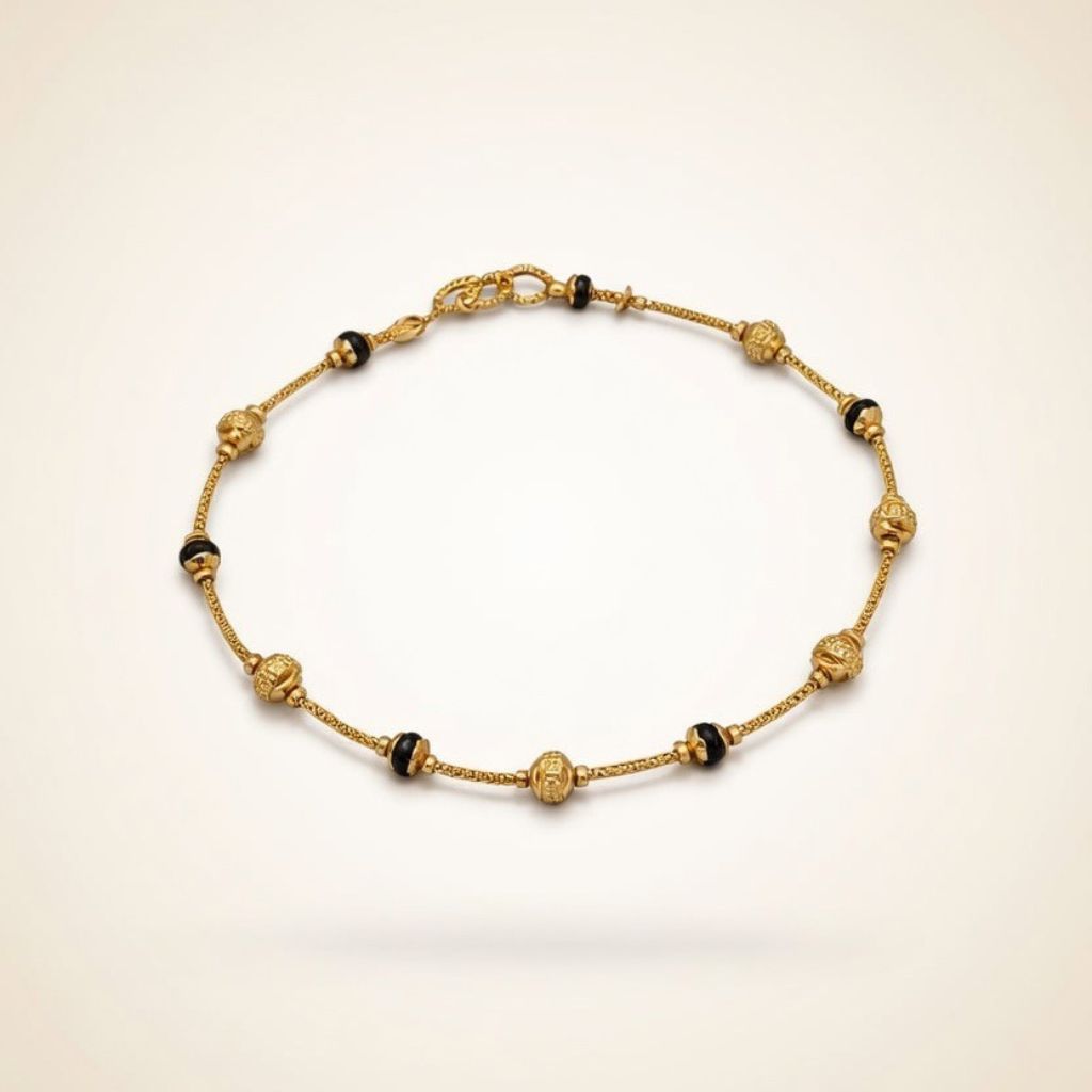 Gold plated mangalsutra bracelet with ornate filigree ball beads and black bead accents flat lay
