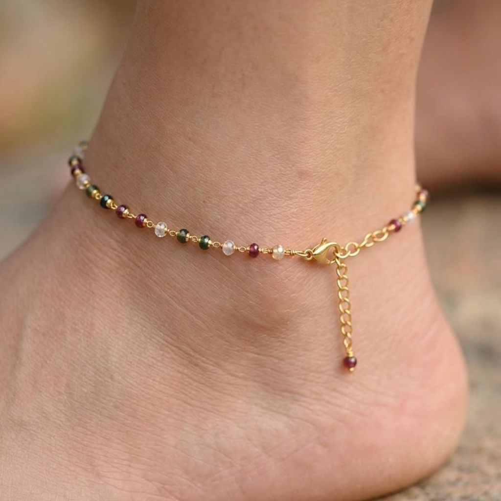 Gold plated multicolour gemstone bead anklet worn on foot standing in water