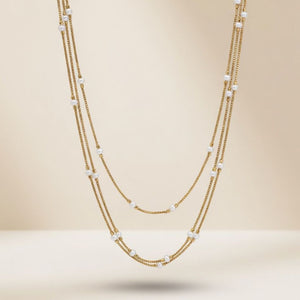 Gold plated triple layer pearl station box chain necklace flat lay product shot