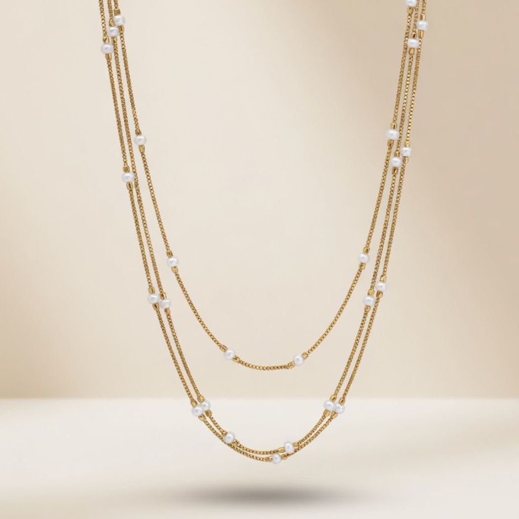 Gold plated triple layer pearl station box chain necklace flat lay product shot