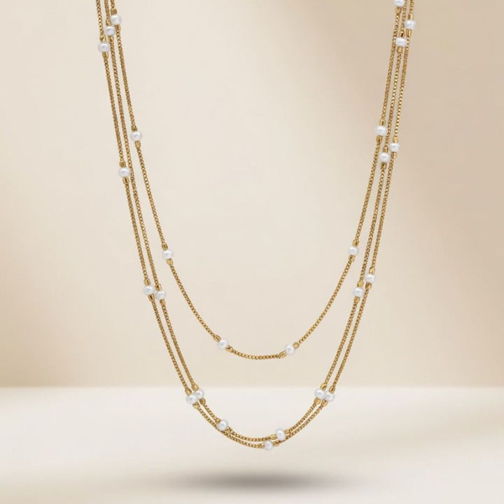 Gold plated triple layer pearl station box chain necklace flat lay product shot