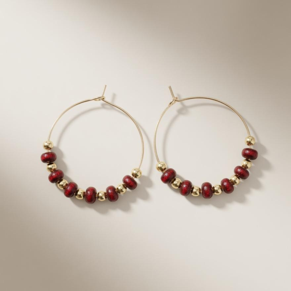Pair of 30mm gold plated hoop earrings with red sandalwood and gold beads on a neutral background