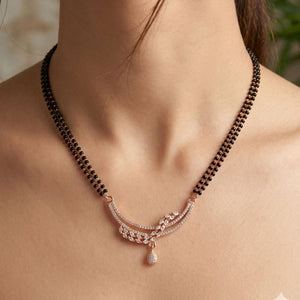 Close up of rose gold double strand mangalsutra with CZ marquise leaf triple bar pendant on model