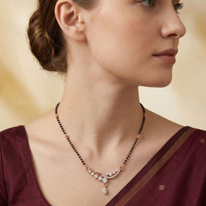 Rose gold plated mangalsutra with CZ crystal teardrop pendant worn by model in maroon saree