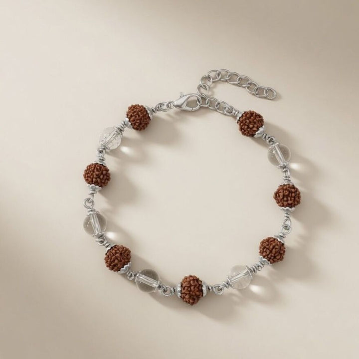 Flat lay of a silver plated Rudraksha and crystal quartz bracelet with lobster clasp on a neutral background
